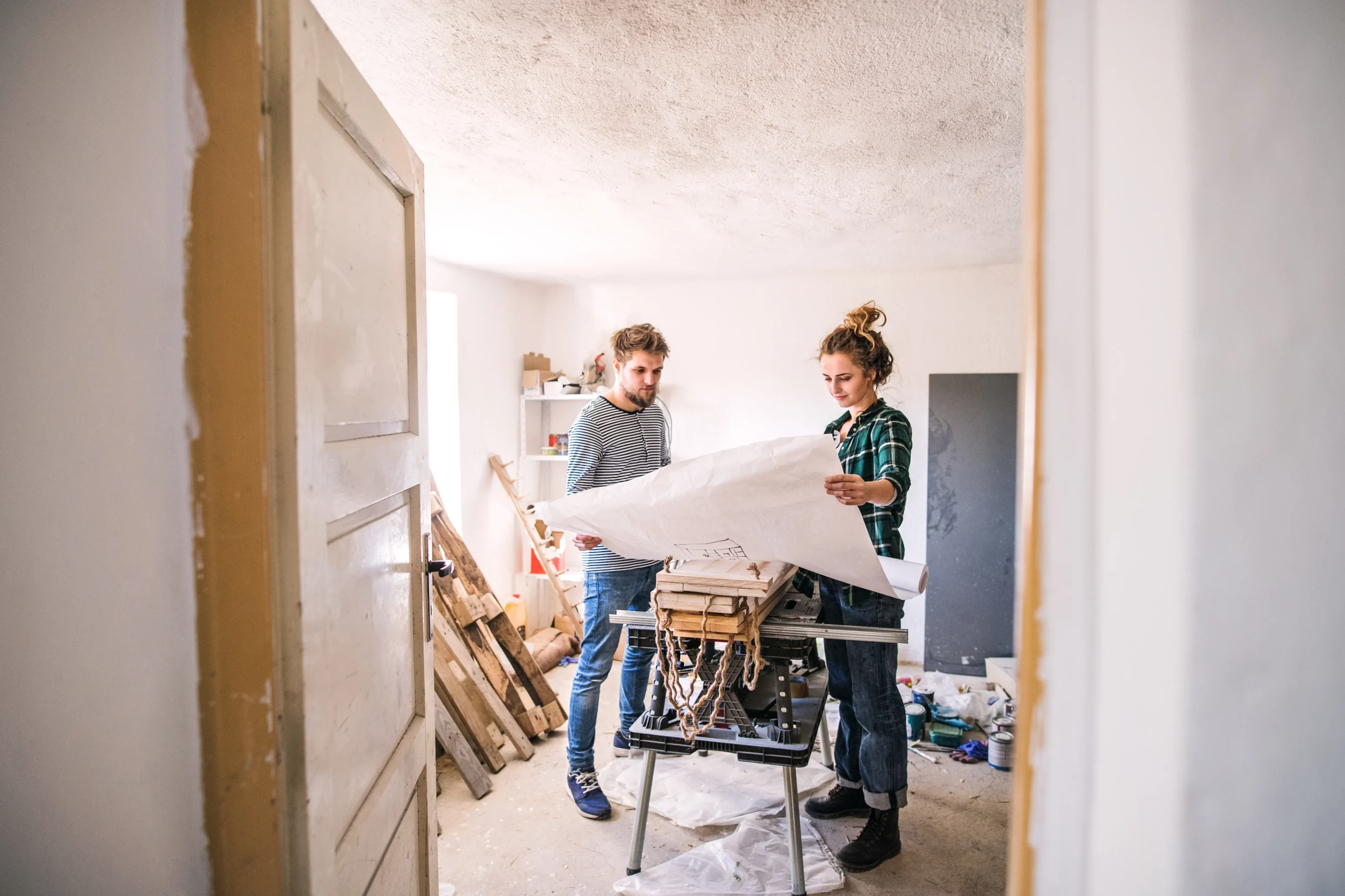 Fotografía de dos personas revisando un plano para asegurarse de conocer bien cómo remodelar una casa sin errores.