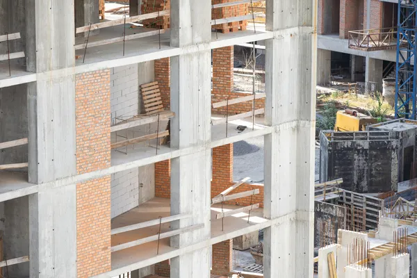 que es un acabado de construcción: Fotografía de un edificio en construcción mientras por dentro están haciendo los acabados necesarios para que sea una propiedad apta para los clientes